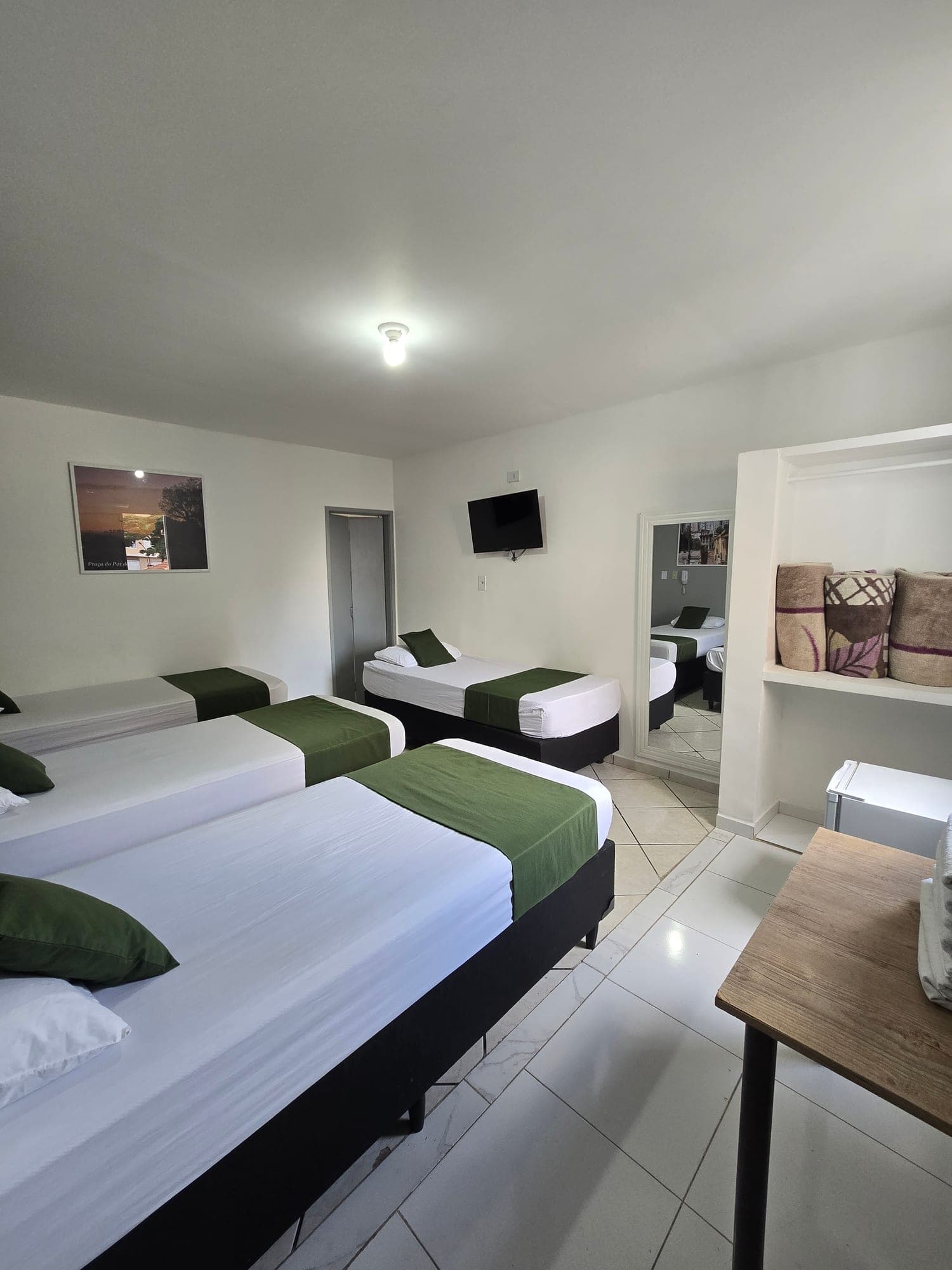 Suíte Quádruplo do Hotel Dona Lú, com cama de casal e camas de solteiro